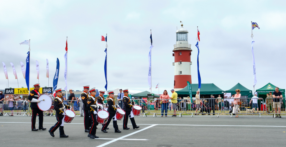 Band walking in front of Smeaton's Tower on Plymouth Hoe
